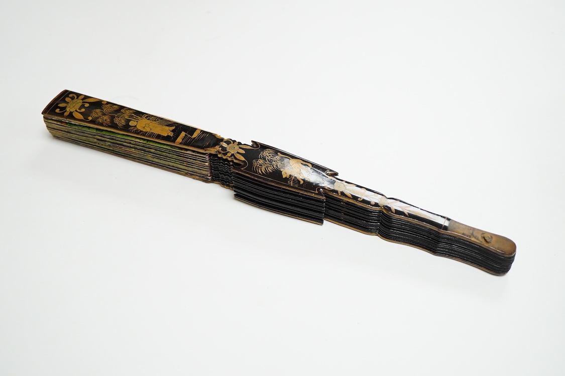 Four 19th century Chinese gilt-decorated black lacquer fans with figure painted leaves, two cased, largest 41cm